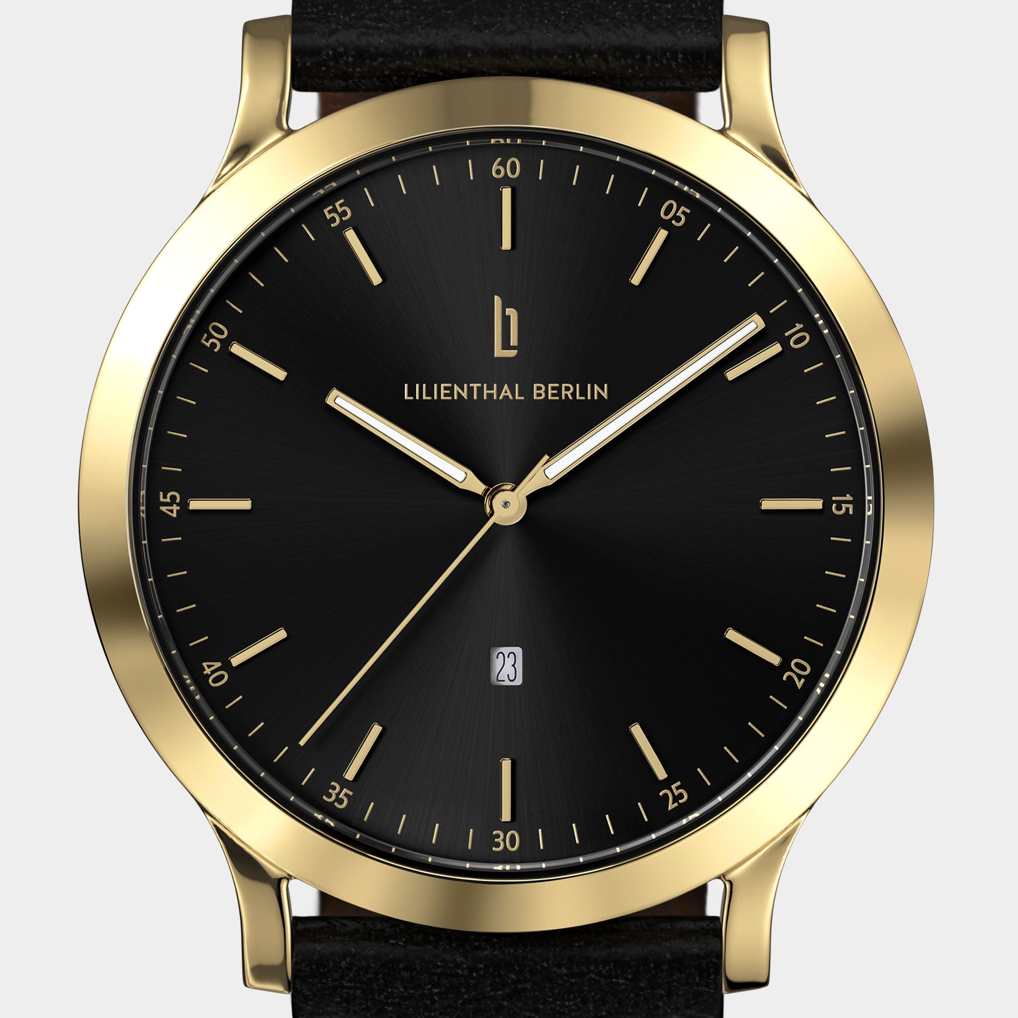 Gold-cased minimalist wristwatch with black dial, gold markers, and leather strap