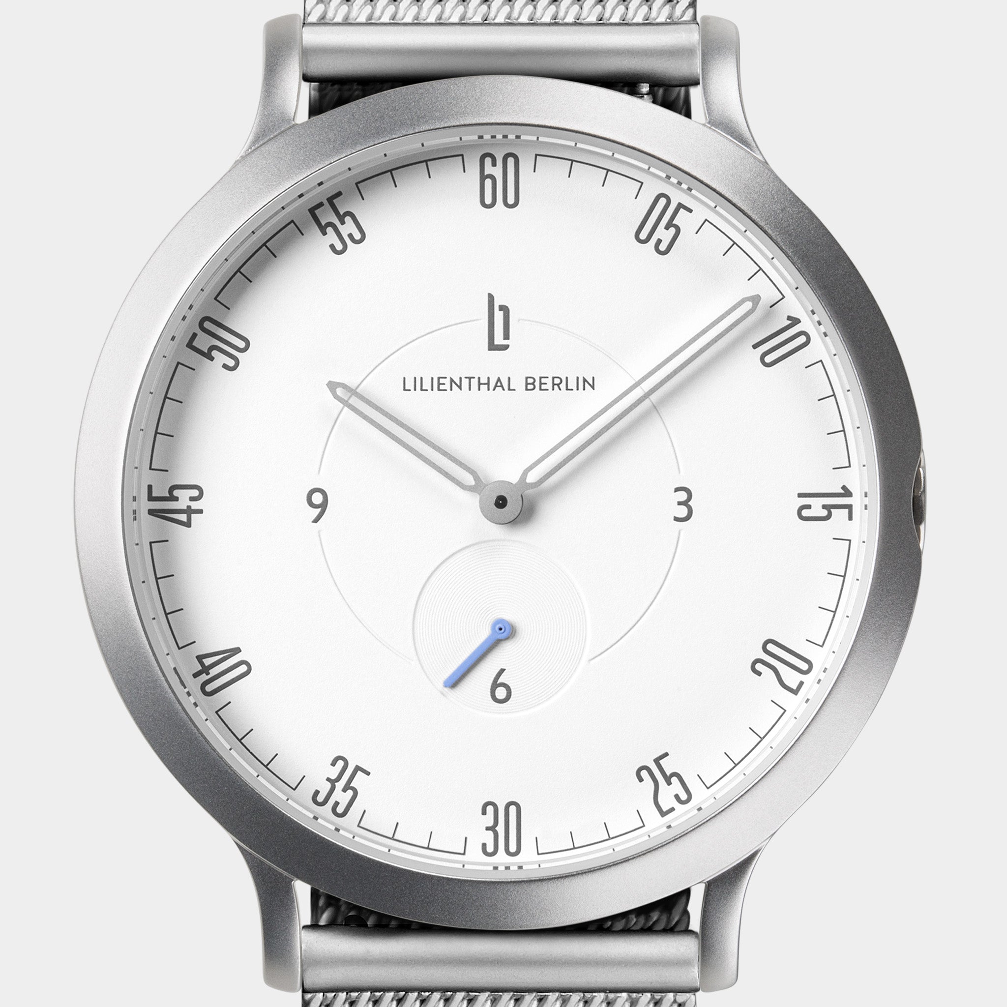 Minimalist silver wristwatch with white dial, mesh strap, and modern hour markers.