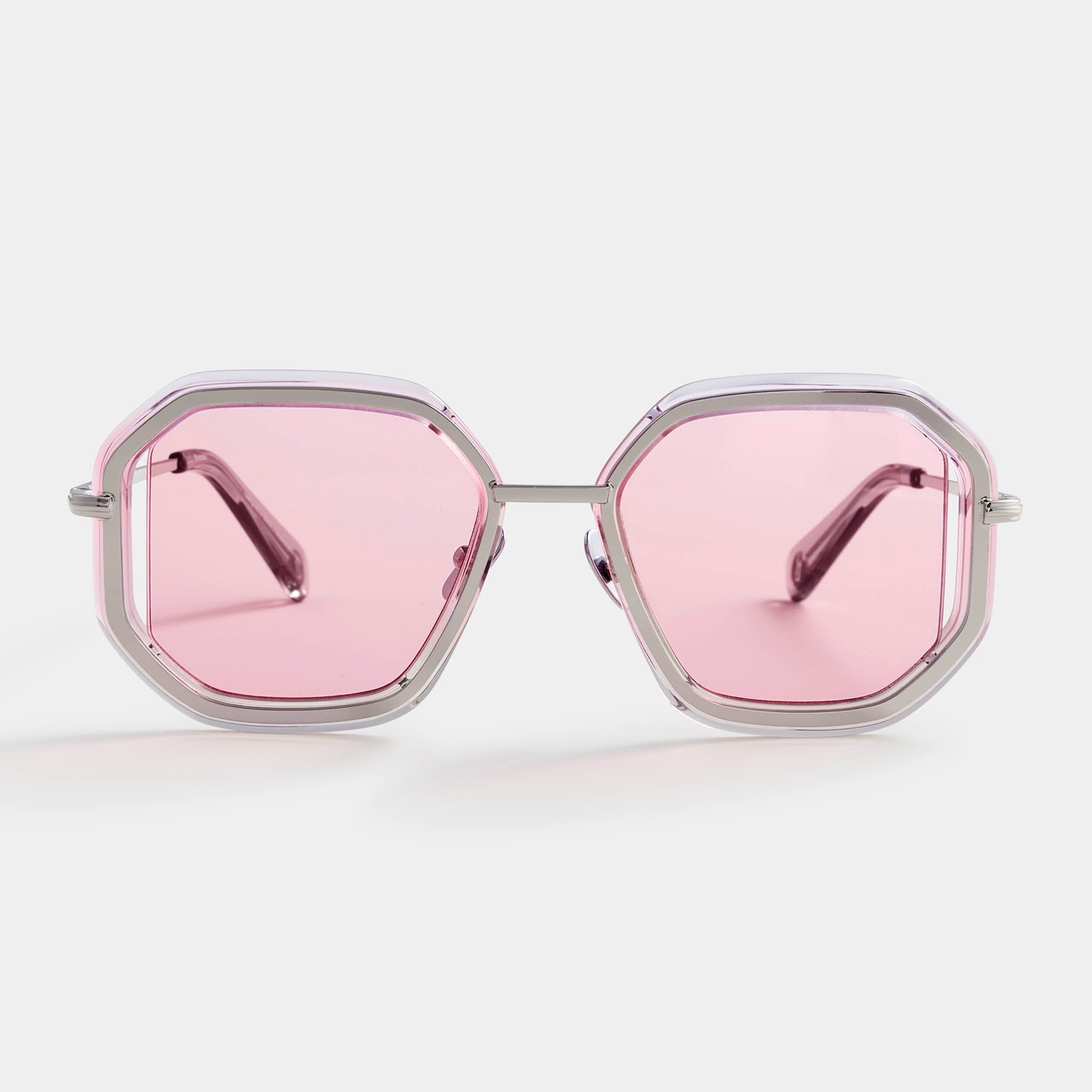 Geometric silver sunglasses with pink tinted lenses on a white background