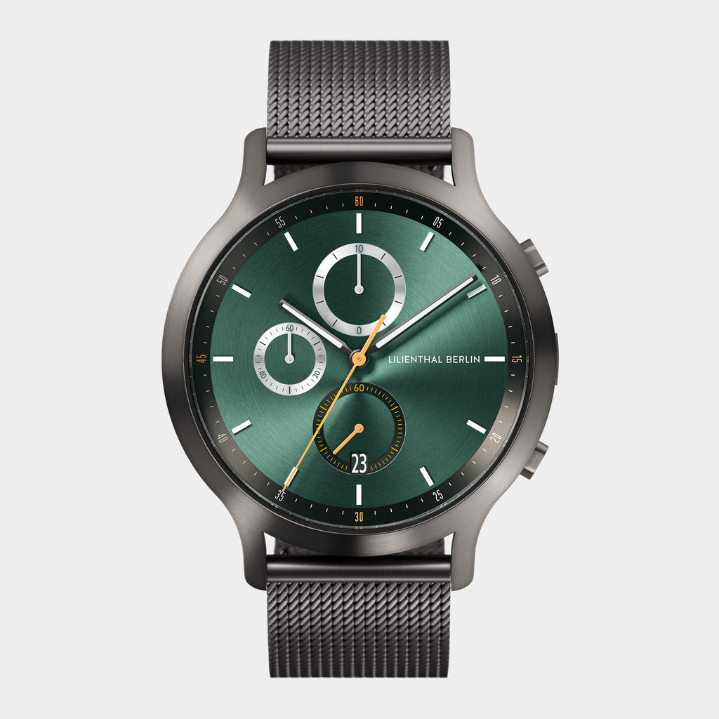 Men's chronograph watch with green dial, mesh strap, and subdials on white background