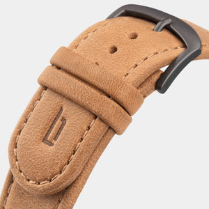 Tan leather watch strap with black metal buckle and stitched detailing, close-up
