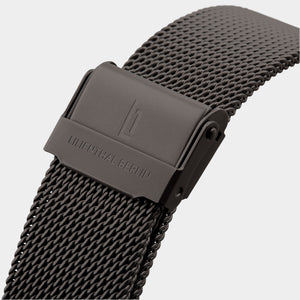 Close-up of black mesh watch strap with engraved clasp on white background