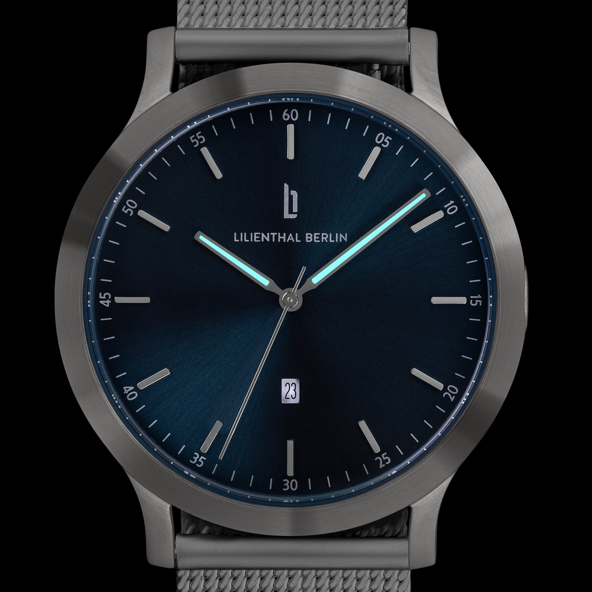 Sleek minimalist wristwatch with dark blue dial, luminous hands, date window, and mesh strap
