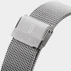 Close-up of stainless steel mesh watch strap with engraved clasp on white background