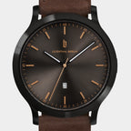 Minimalist black and brown wristwatch with date display and leather strap