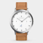 Minimalist watch with white dial, tan leather strap, and silver case on white background.