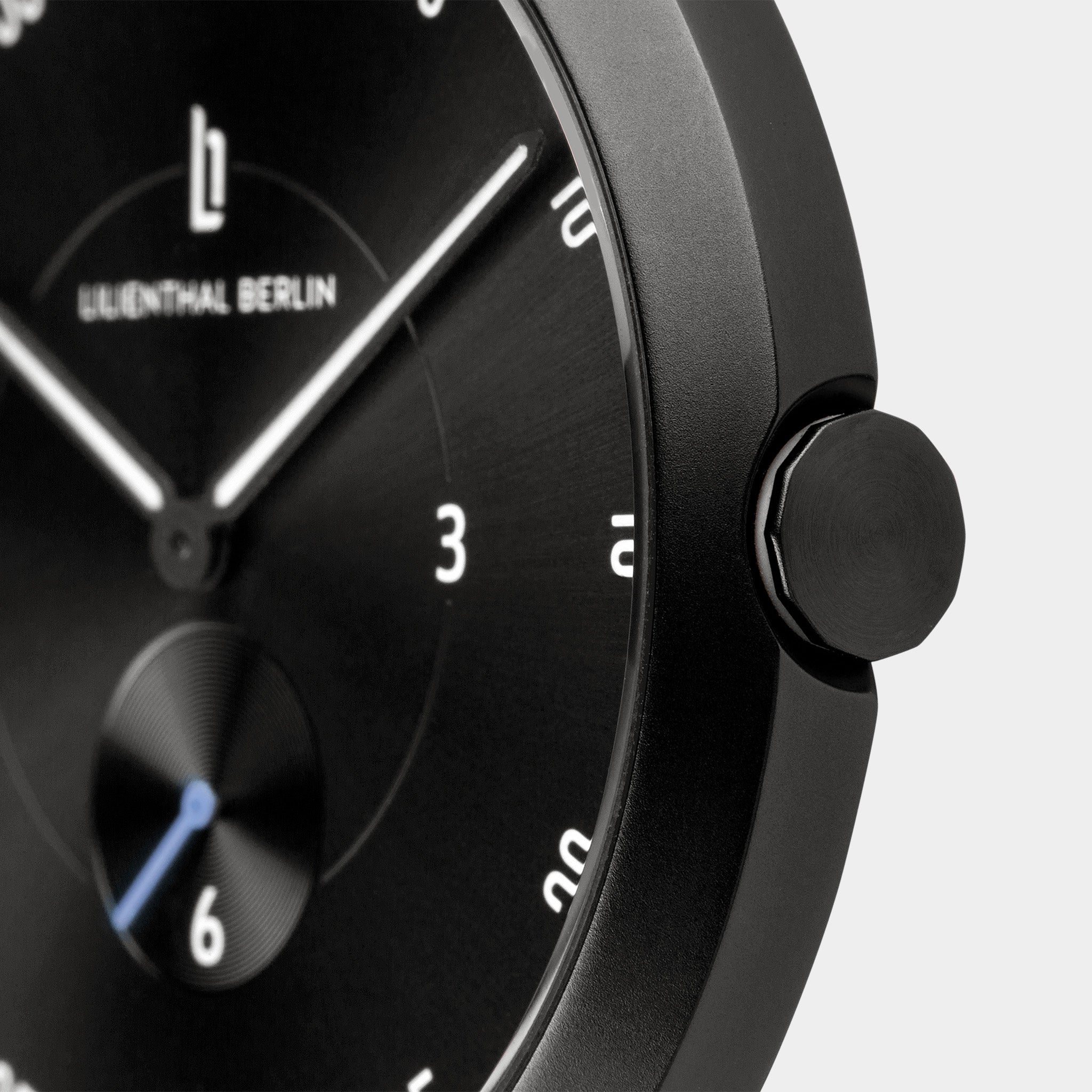 Close-up of a black minimalist wristwatch face with white hands and hour markers