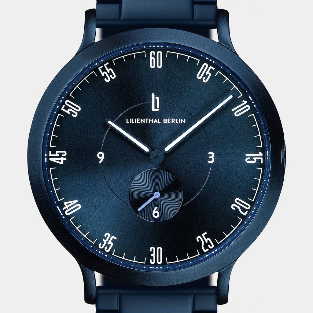 Modern blue analog wristwatch with minimalist dial and subdial on a metal band