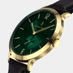 Gold wristwatch with green dial, gold markers, black leather strap, and minimalist design.